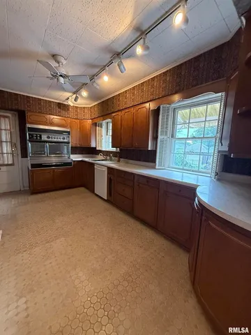 a kitchen with stainless steel appliances kitchen island granite countertop a sink counter space cabinets and a window