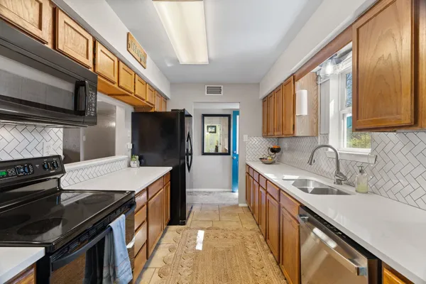 a kitchen with stainless steel appliances granite countertop a sink stove and refrigerator