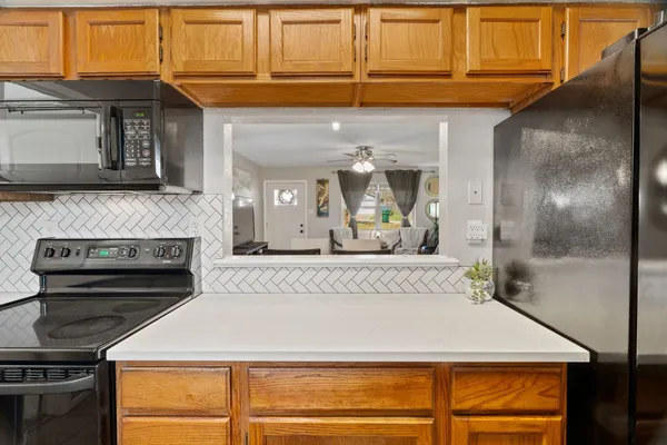 a view of kitchen with granite countertop stainless steel appliances and cabinets