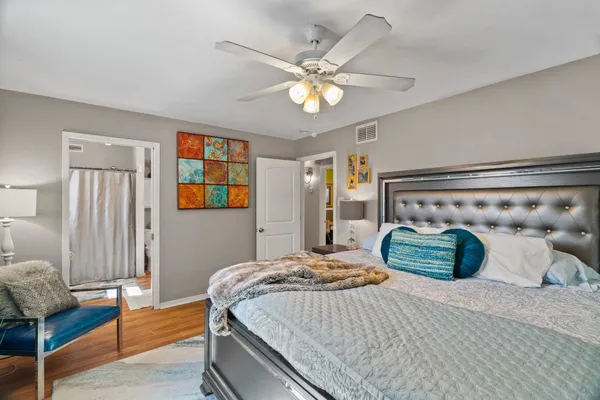 a bedroom with a bed and wooden floor
