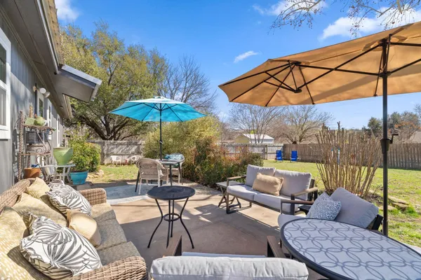 a view of a patio with a table and chairs under an umbrella