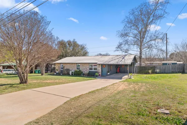 a front view of a house with a yard and trees
