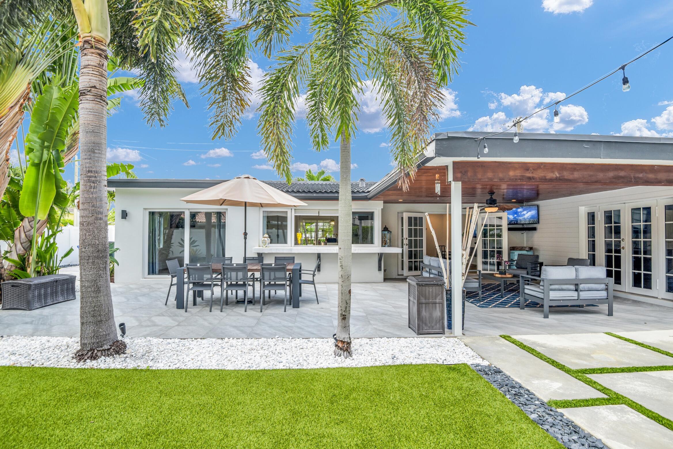 701 Appleby Street Boca Raton, FL 33487 - Photo 20 of 47 a view of a patio with table and chairs potted plants and palm trees