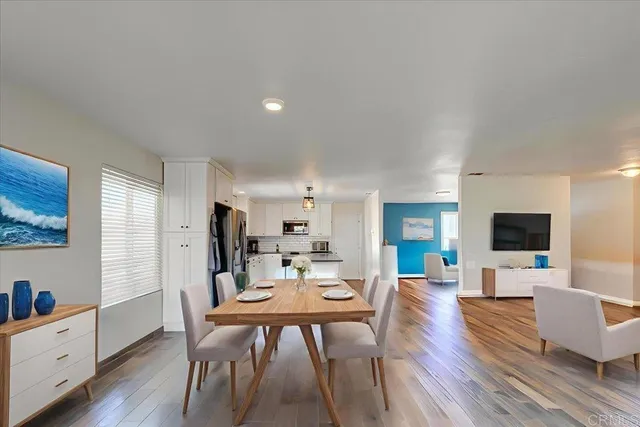 a living room with furniture a wooden floor and a flat screen tv