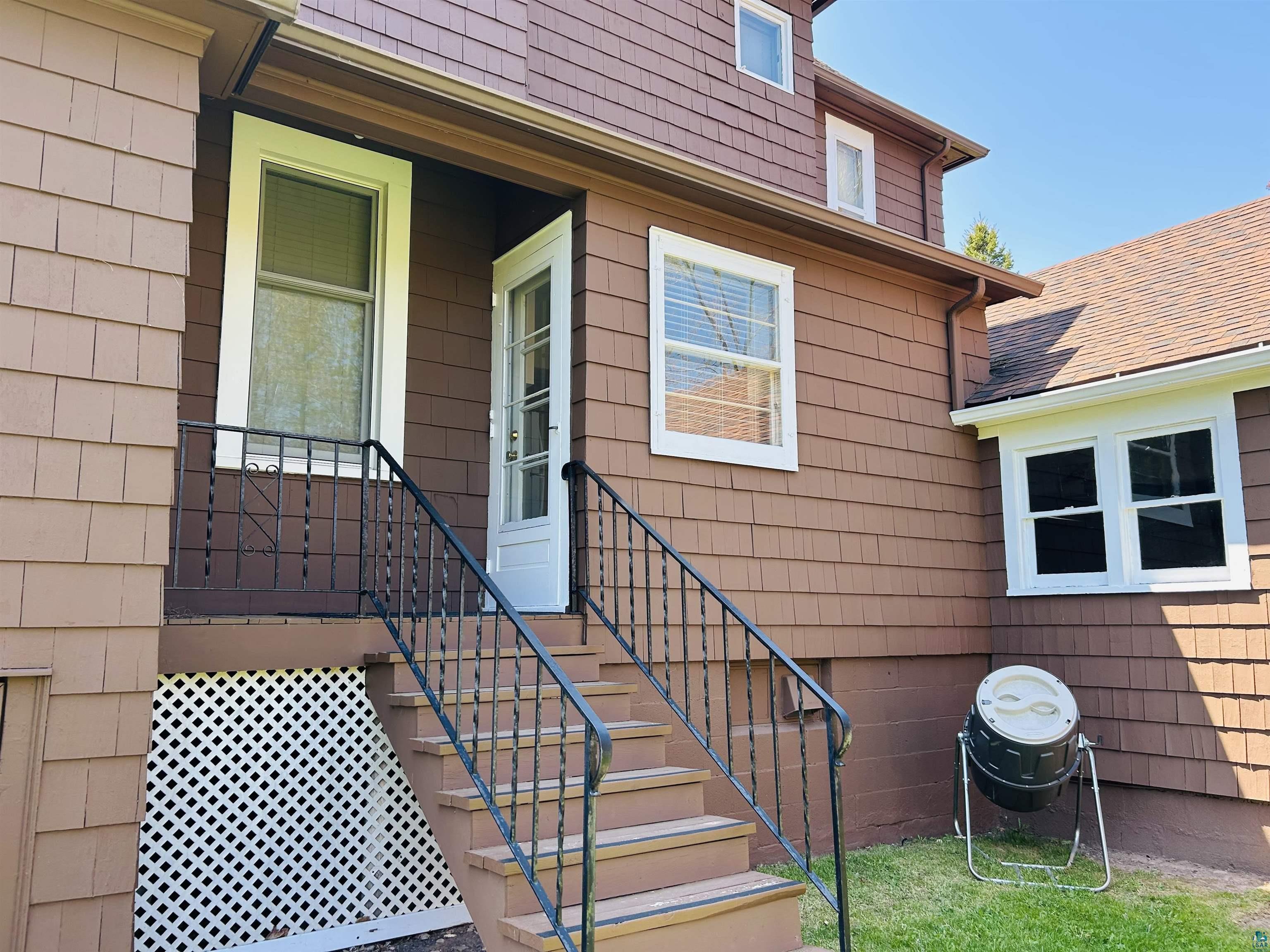 5090 London Road, Unit 1 Duluth, MN 55804 - Photo 34 of 54 Terraced entry featuring a white paneled door, black wrought iron railing, and wood-finish steps