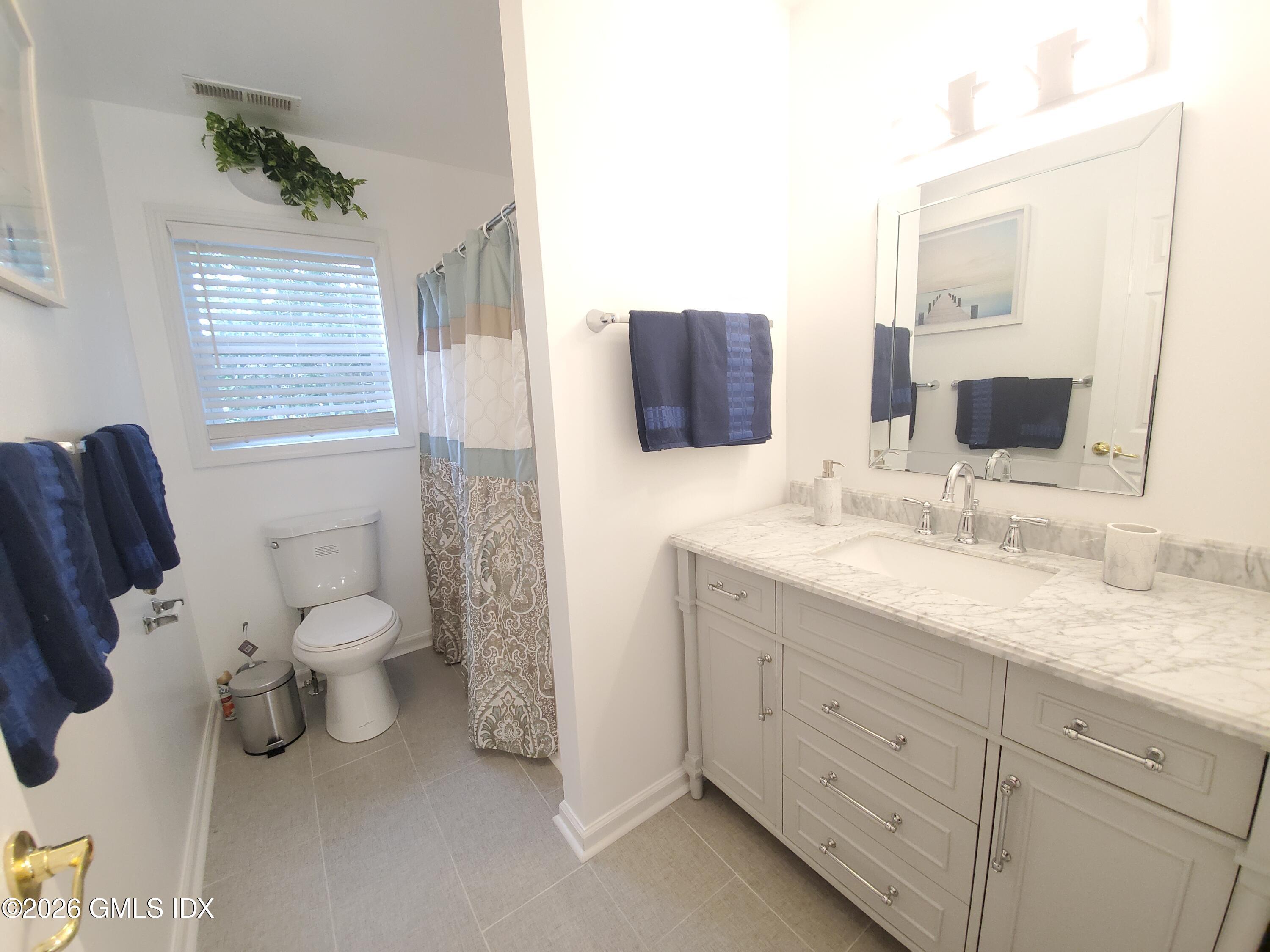 92 Valley Road, Unit B Cos Cob, CT 06807 - Photo 14 of 46 a bathroom with a toilet sink and mirror