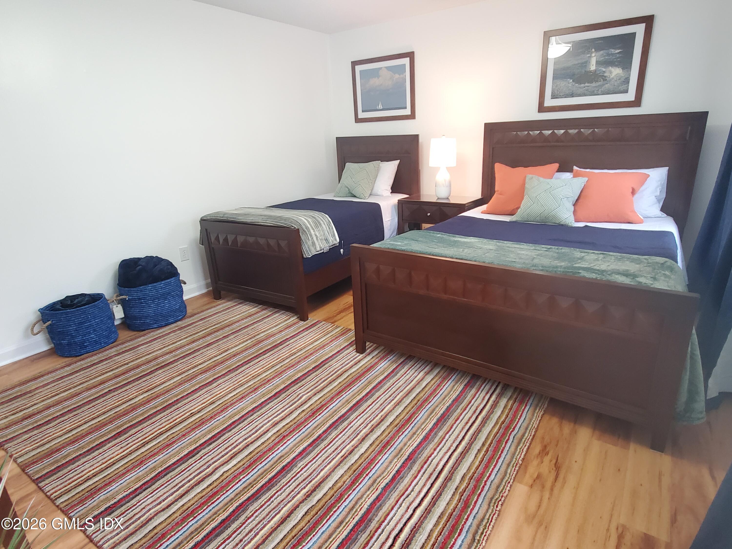 92 Valley Road, Unit B Cos Cob, CT 06807 - Photo 15 of 46 a bedroom with two beds and a lamp on dresser