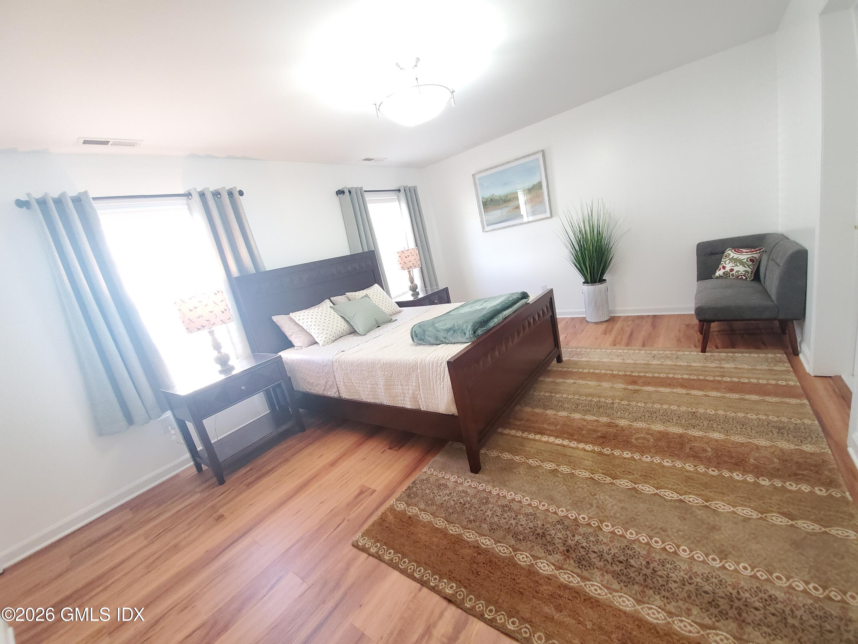 92 Valley Road, Unit B Cos Cob, CT 06807 - Photo 17 of 46 a spacious bedroom with a bed wooden floor and window