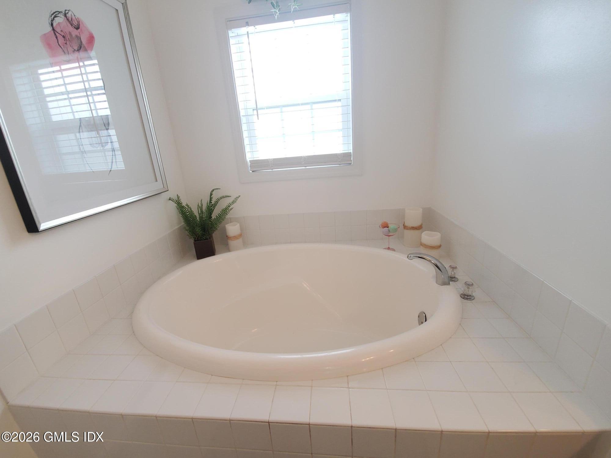 92 Valley Road, Unit B Cos Cob, CT 06807 - Photo 19 of 46 a white bath tub sitting in a bathroom next to a window