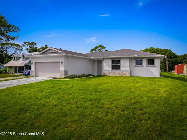 a front view of a house with a garden