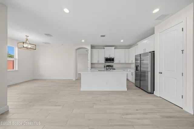 a large kitchen with stainless steel appliances a refrigerator and a stove top oven