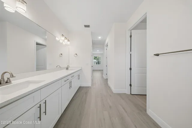 a spacious bathroom with a double vanity sink and a mirror
