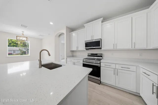 a kitchen with stainless steel appliances granite countertop a stove a sink and a microwave