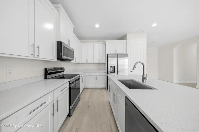 a kitchen with white cabinets and stainless steel appliances