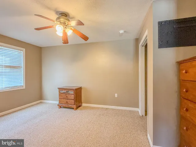 a view of an empty room with window and cabinet