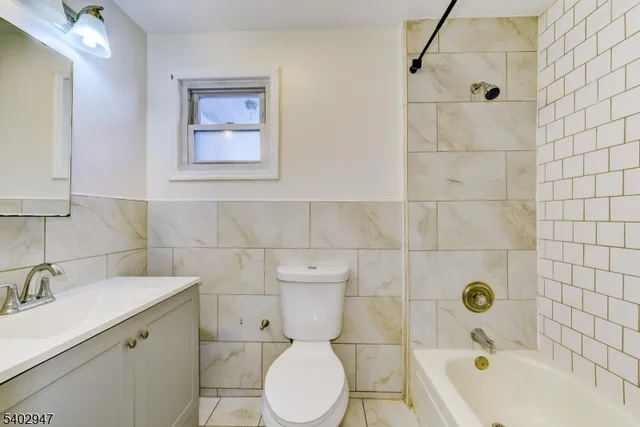 a bathroom with a sink mirror bathtub and toilet