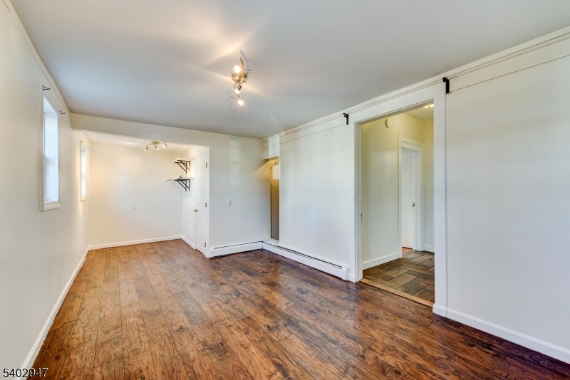 946 West 7th Street, Unit 1 Plainfield, NJ 07063 - Photo 12 of 14 a view of an empty room with wooden floor and a window