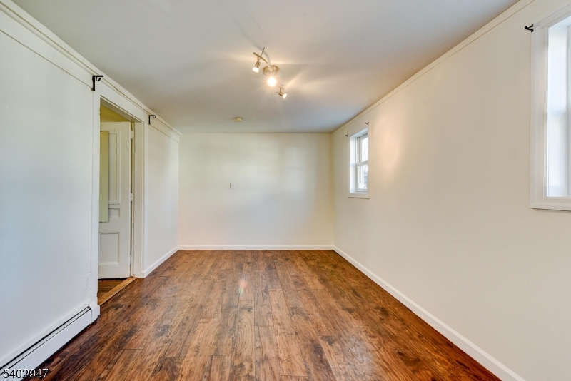 946 West 7th Street, Unit 1 Plainfield, NJ 07063 - Photo 13 of 14 an empty room with wooden floor and windows