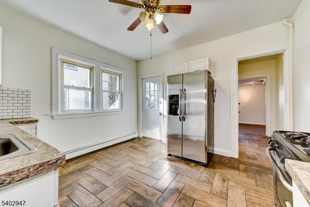 a view of a livingroom with wooden floor and a kitchen space