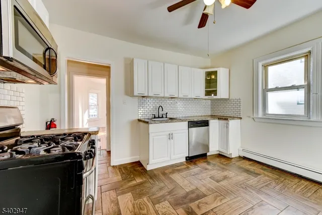 a kitchen with a stove cabinets and a window