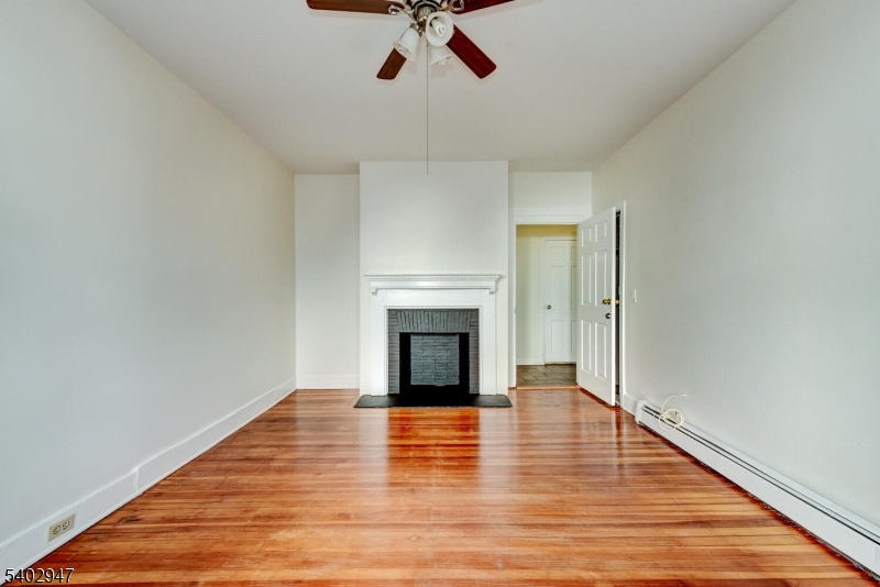 946 West 7th Street, Unit 1 Plainfield, NJ 07063 - Photo 10 of 14 a view of a livingroom with wooden floor a fireplace and window