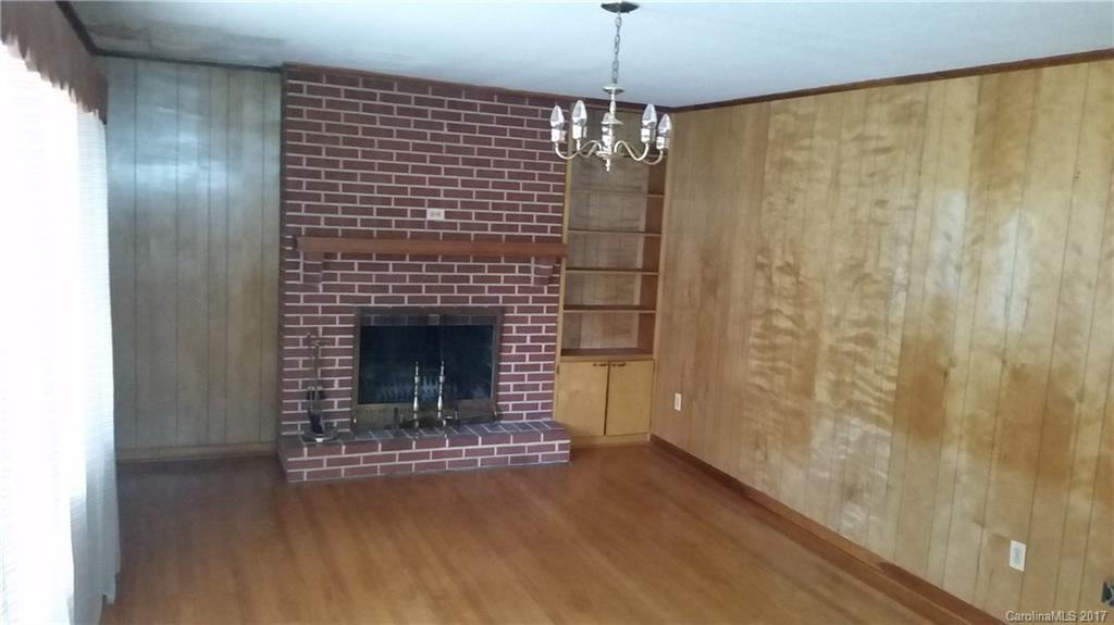 502 Wilson Cove Road Canton, NC 28716 - Photo 15 of 18 a living room with a fireplace and a chandelier