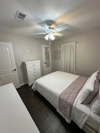 a bedroom with a bed and a ceiling fan
