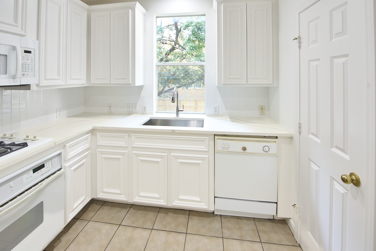 918 Cohn Street Houston, TX 77007 - Photo 11 of 32 a kitchen with white cabinets and white appliances