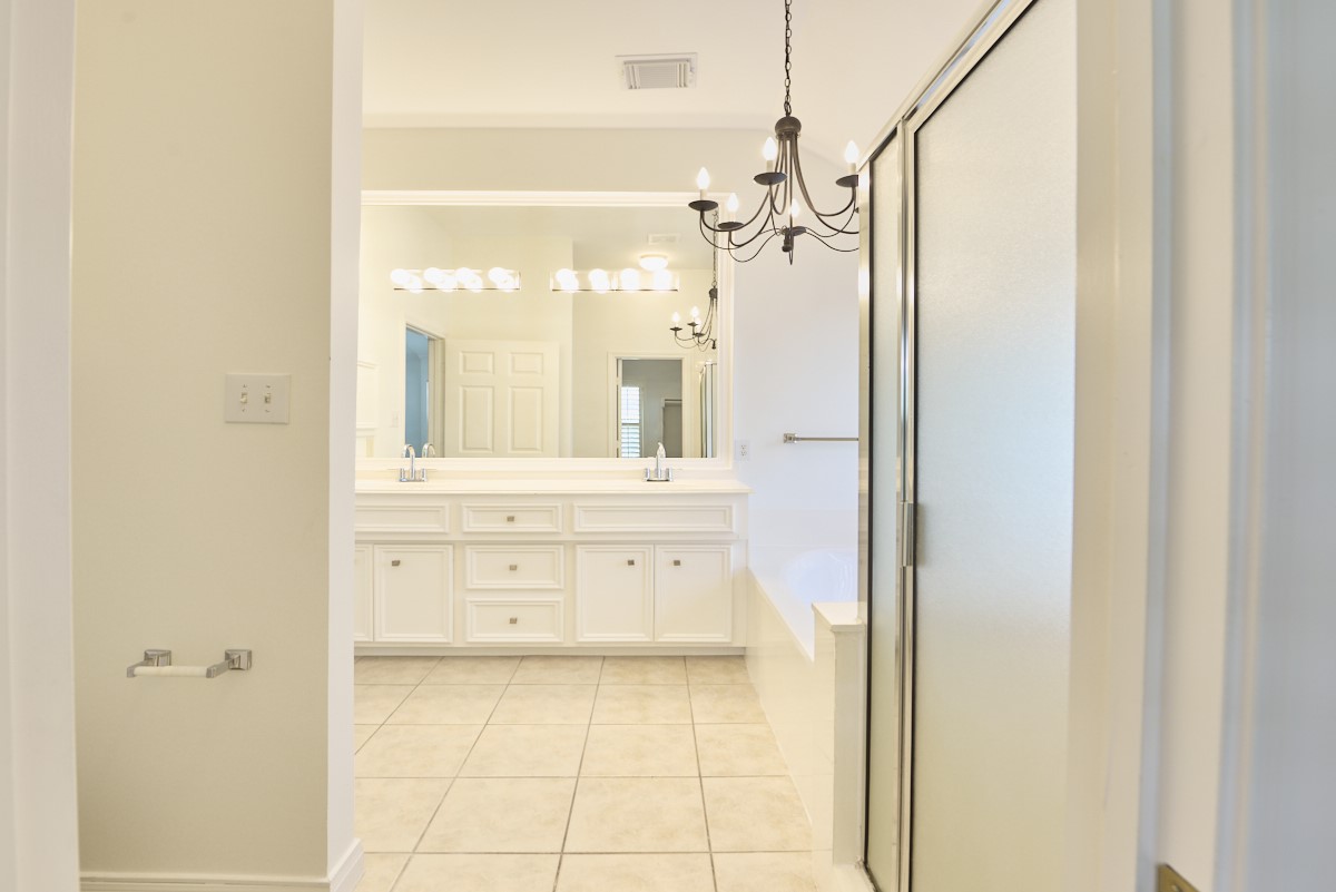 918 Cohn Street Houston, TX 77007 - Photo 17 of 32 a bathroom with a granite countertop sink mirror and a shower