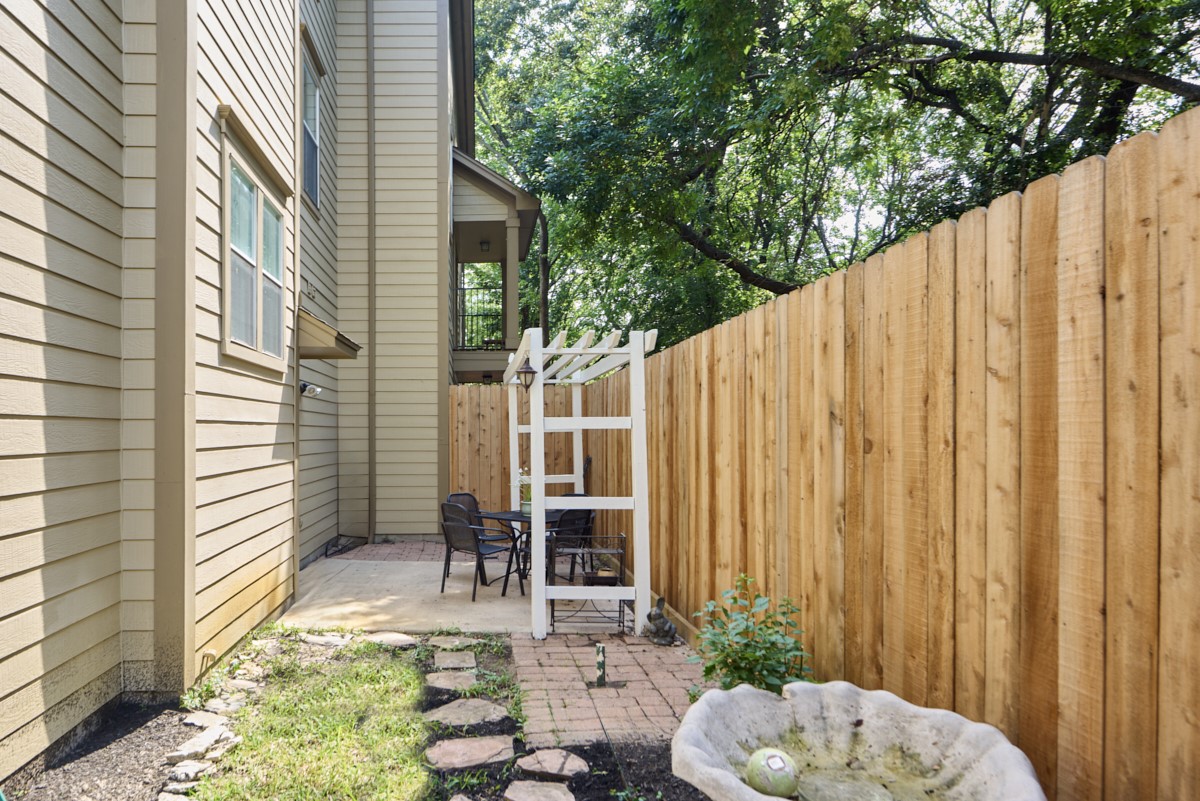 918 Cohn Street Houston, TX 77007 - Photo 24 of 32 a backyard of a house with table and chairs with wooden fence and plants