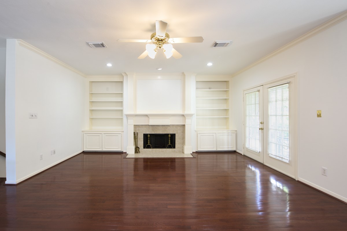 918 Cohn Street Houston, TX 77007 - Photo 5 of 32 an empty room with wooden floor fireplace and windows