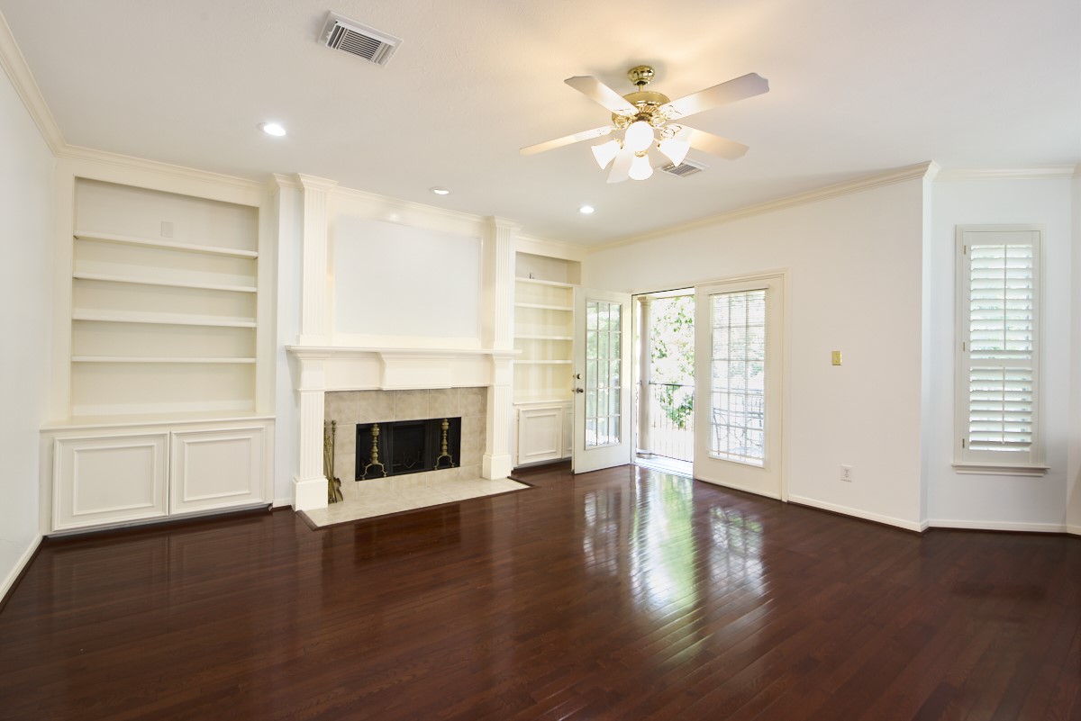 918 Cohn Street Houston, TX 77007 - Photo 7 of 32 an empty room with wooden floor fireplace and windows