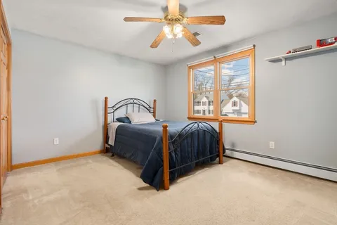 a bedroom with a bed lamp and a chandelier