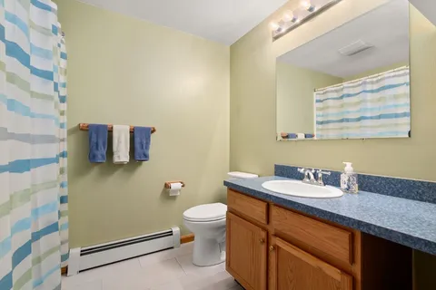 a bathroom with a granite countertop sink mirror vanity and toilet