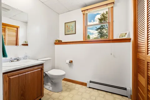 a bathroom with a granite countertop sink mirror and toilet