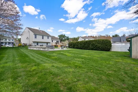 a view of a house with a big yard and large tree