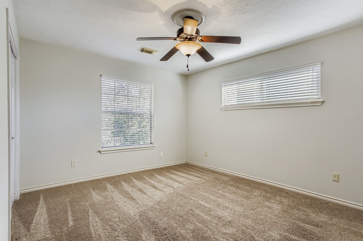 8518 Rebawood Drive Humble, TX 77346 - Photo 20 of 36 Bedroom 2 upstairs, features plush carpeting, abundant natural light through dual windows, and a stylish ceiling fan for ultimate comfort.
