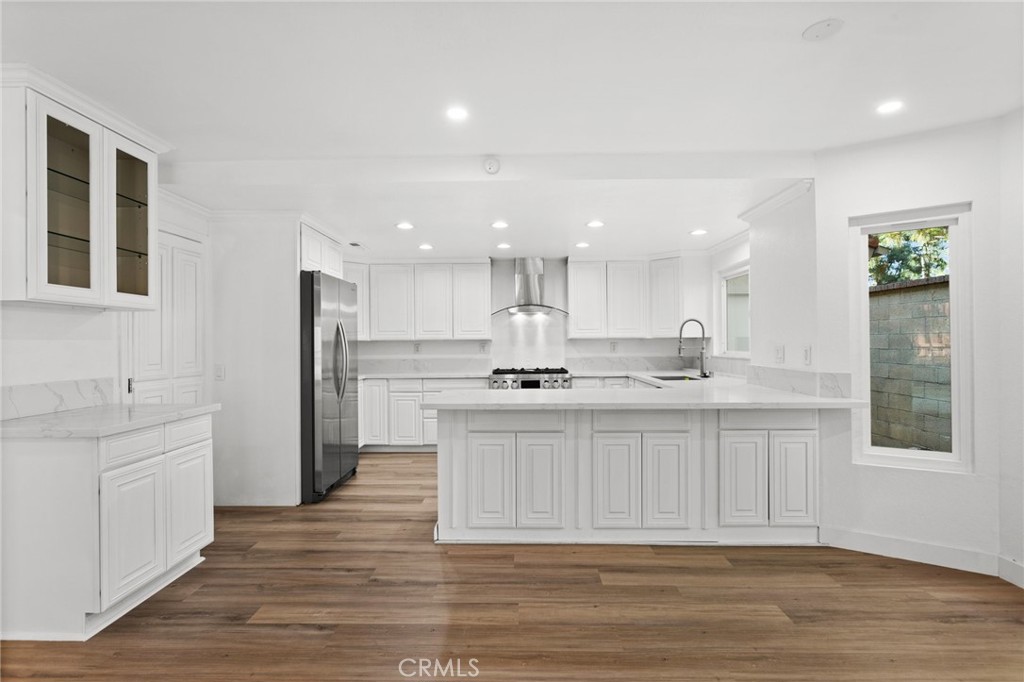 a large kitchen with kitchen island a sink stainless steel appliances and cabinets