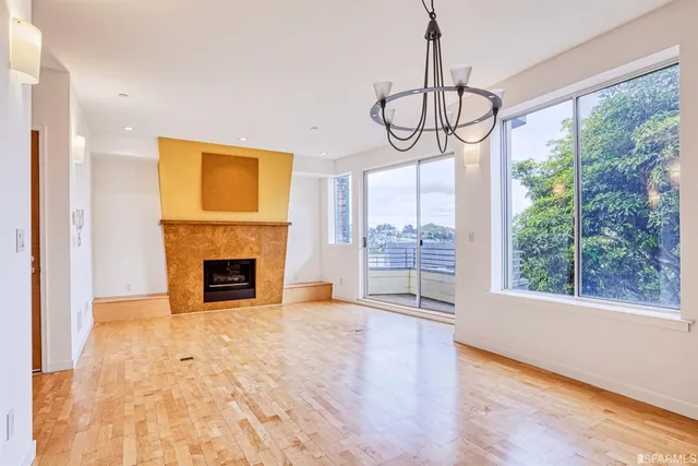 a view of an empty room with a fireplace and a window