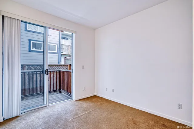 an empty room with floor to ceiling window and entryway