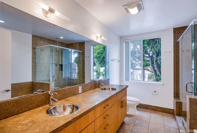 a bathroom with a granite countertop sink and a large mirror