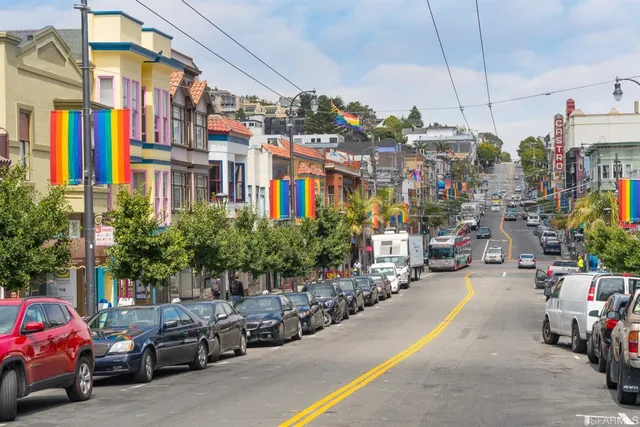 a city street lined with parked cars and buildings