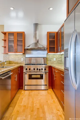 a kitchen with stainless steel appliances granite countertop a stove a sink and a refrigerator