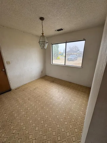 en empty room with windows and ceiling fan