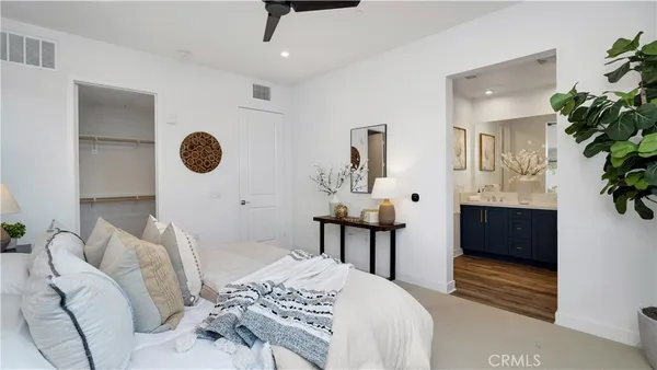 a bedroom with a bed and a potted plant