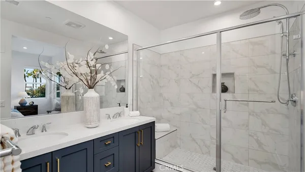 a bathroom with a double vanity sink mirror and shower
