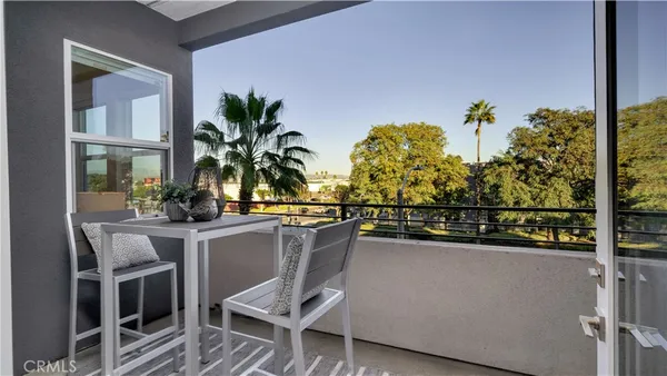 a view of balcony with chairs potted plants and wooden floor
