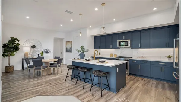 a kitchen with a table chairs sink and cabinets