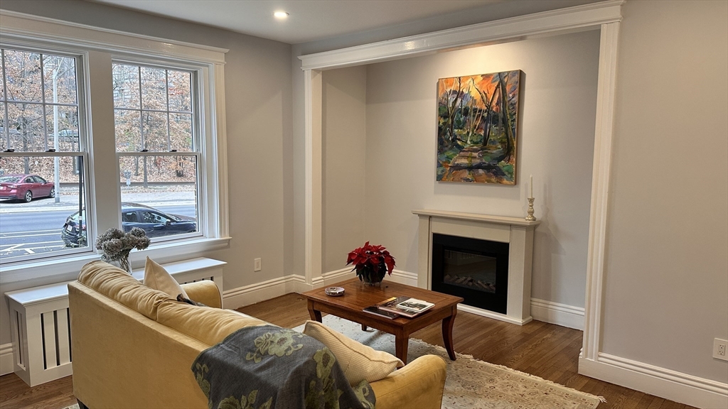 1521 Beacon Street, Unit 1 Brookline, MA 02446 - Photo 5 of 15 a living room with furniture a fireplace and a large window