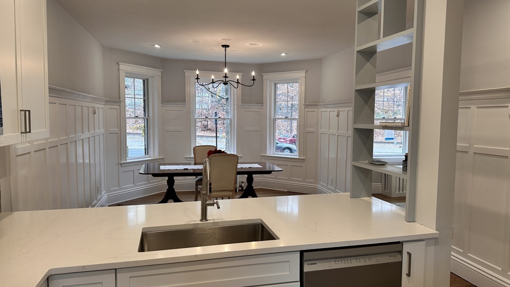 1521 Beacon Street, Unit 1 Brookline, MA 02446 - Photo 7 of 15 a kitchen with a table chairs and chandelier